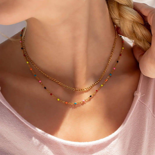 Close-up of a woman wearing a gold necklace with colorful beads.