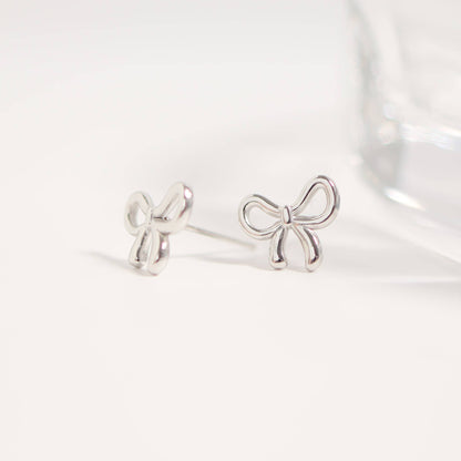 Silver bow-shaped earrings on a white background